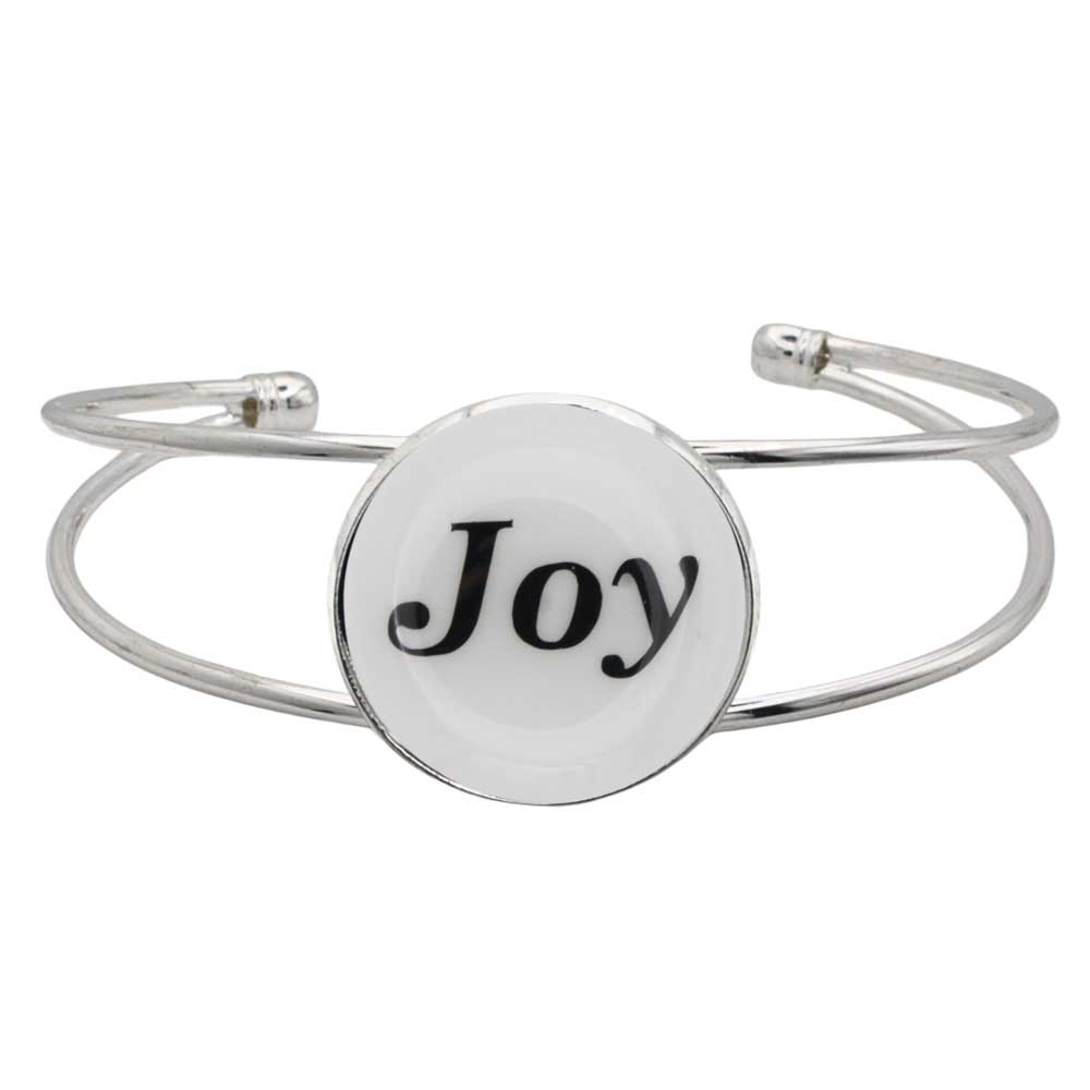 A silver-toned metal cuff bracelet featuring a round white disc with the word 'Joy' printed in black script, shown on a plain white background – Lilylin Designs