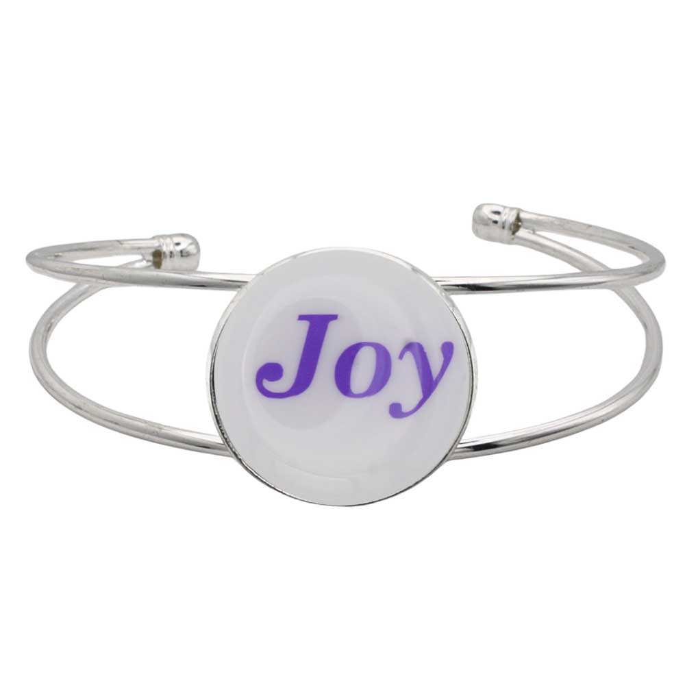 A silver-toned metal cuff bracelet featuring a round white disc with the word 'Joy' printed in purple script, shown on a plain white background – Lilylin Designs
