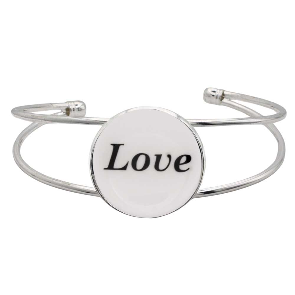 A silver-toned metal cuff bracelet featuring a round white disc with the word “Love” printed in black script, shown on a plain white background – Lilylin Designs