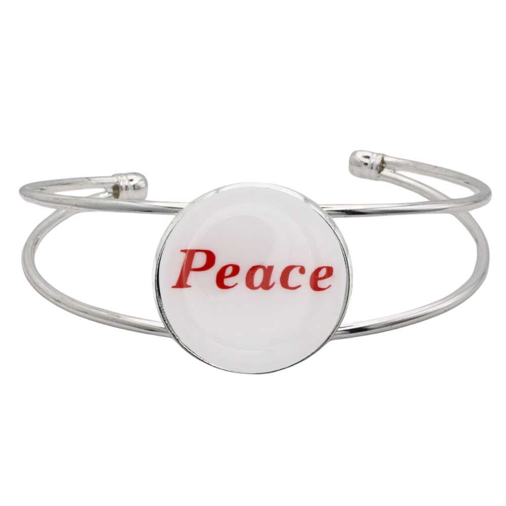 A silver-toned metal cuff bracelet featuring a round white disc with the word “Peace” printed in red script, shown on a plain white background – Lilylin Designs