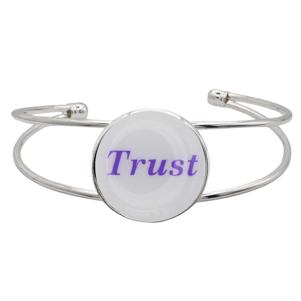 A silver-toned metal cuff bracelet featuring a round white disc with the word "Trust" printed in purple script, shown on a plain white background – Lilylin Designs