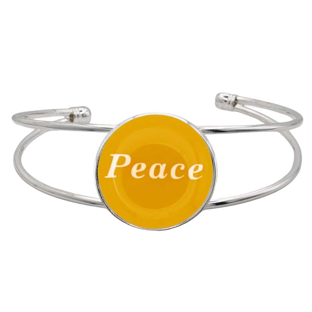 A silver-toned metal cuff bracelet featuring a round yellow disc with the word 'Peace' printed in white script, shown on a plain white background – Lilylin Designs