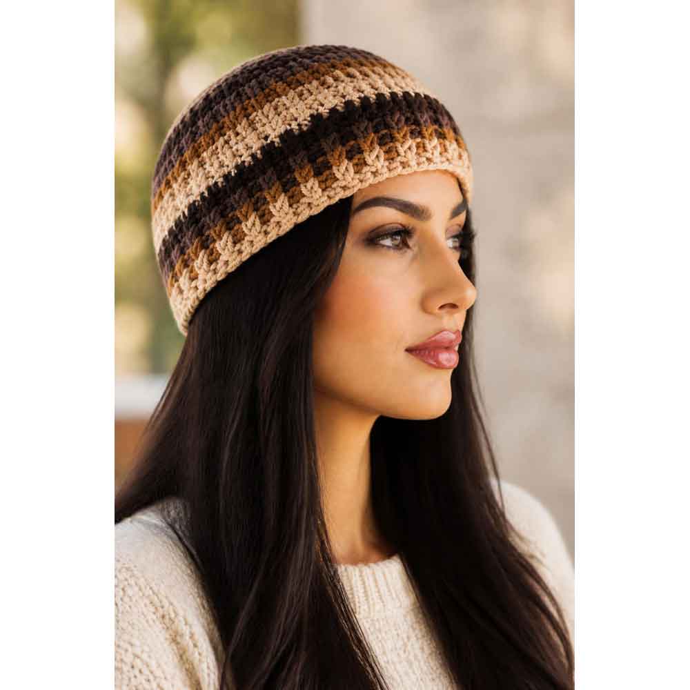 Side view of view of model wearing brown, tan, and dark brown crochet hat with a cream sweater