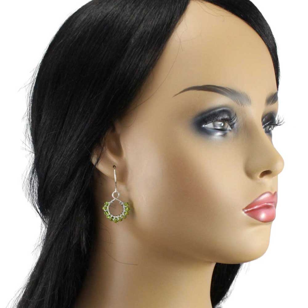 Model with handcrafted wire wrapped green bead earrings on a white background - Lilylin Designs