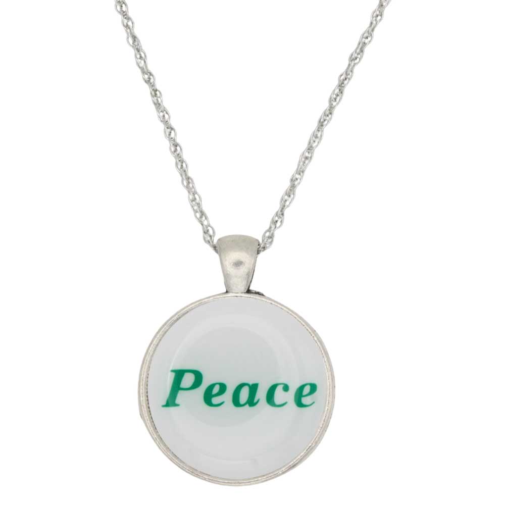 A silver round pendant necklace featuring the word 'Peace' printed in green text on a white background, suspended from a silver chain - Lilylin Designs