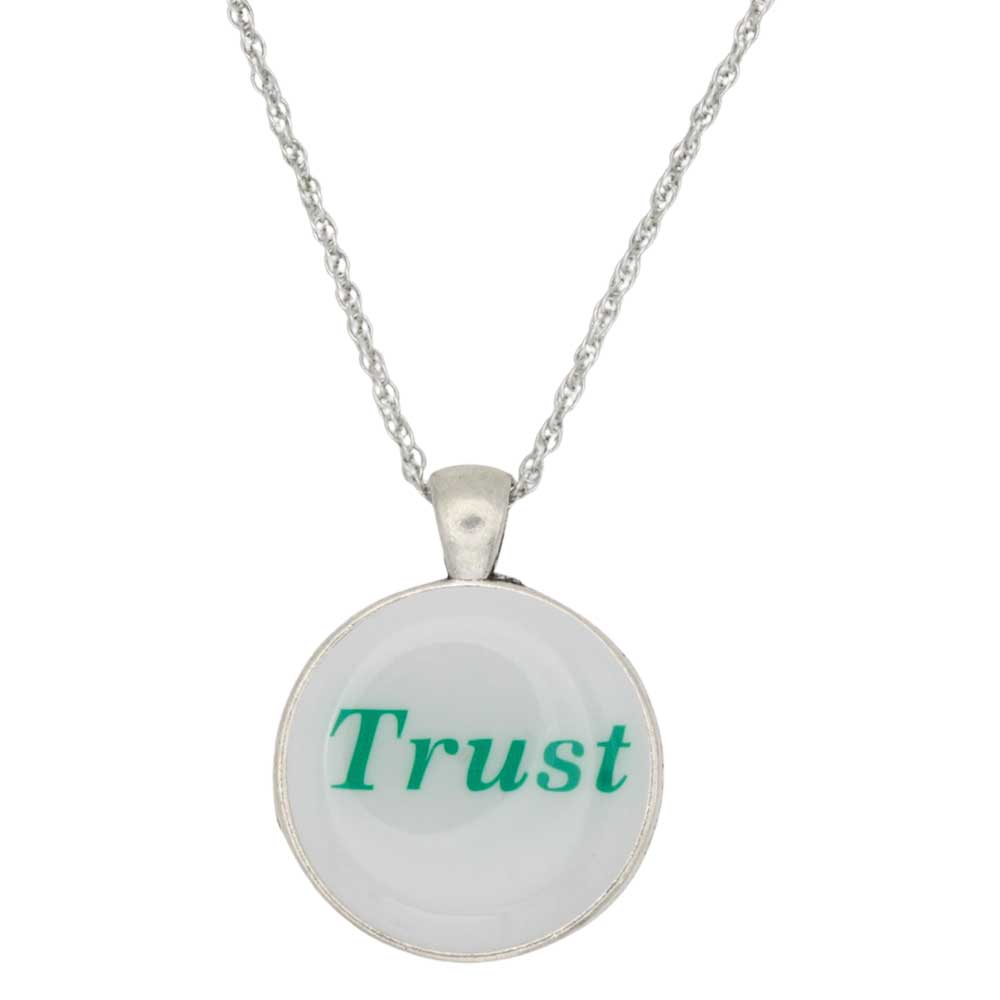 A silver chain necklace with a round pendant featuring the word 'Trust' in green text on a white background, shown against a plain white backdrop - Lilylin Designs